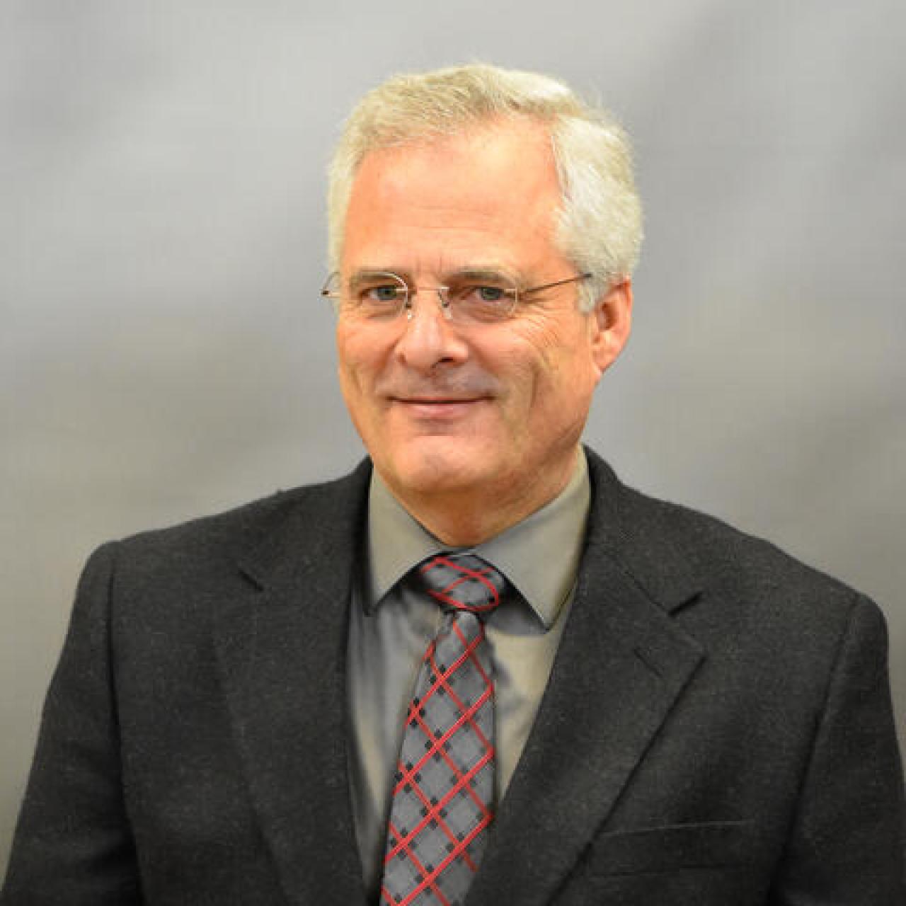 Howard Greene smiling and wearing a suit