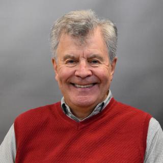 Dave Williams smiling and wearing a red sweater